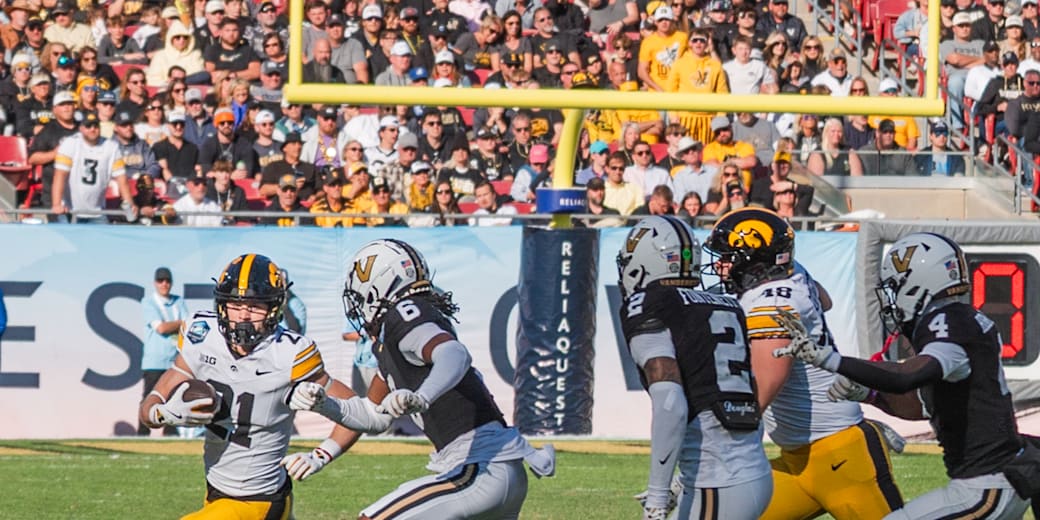 An Iowa ball carrier runs past Vanderbilt defenders
