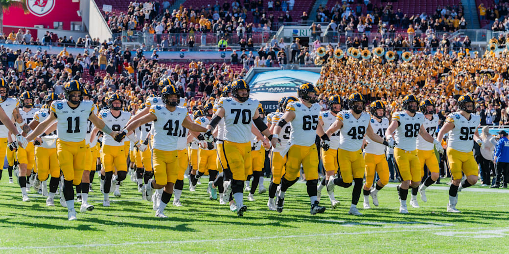 Iowa players run onto the field at Raymond James Stadium