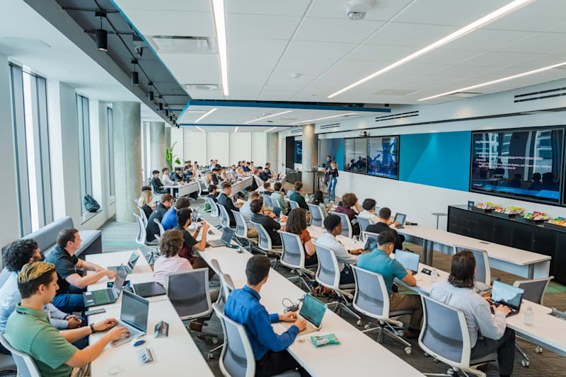 Students at desks during a ReliaQuest Labs cybersecurity training session
