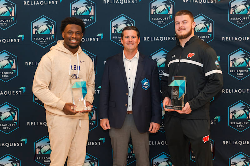 Make It Possible award winners from LSU and Wisconsin holding their trophies alongside a ReliaQuest leader